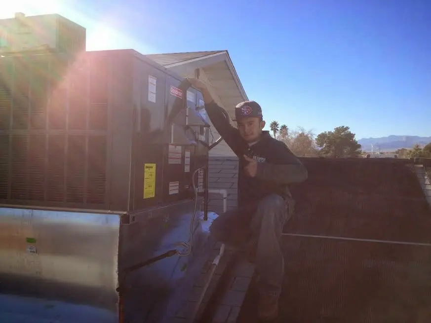 HVAC technician performing AC Tune-Up on a rooftop unit in West Samoset